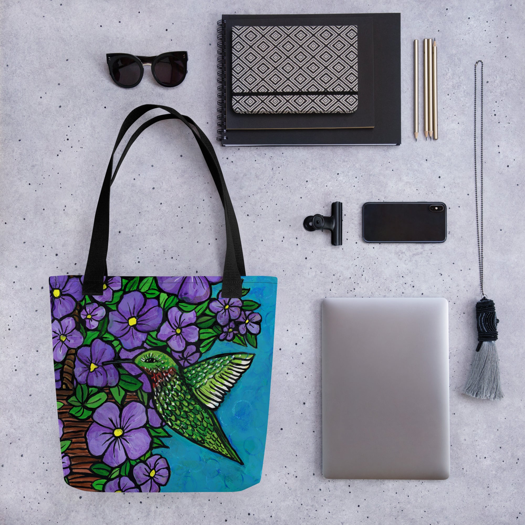 Hummingbird Tote Bag shown with sunglasses, notebooks, agenda, pencils, clip, phone, laptop, and lanyard