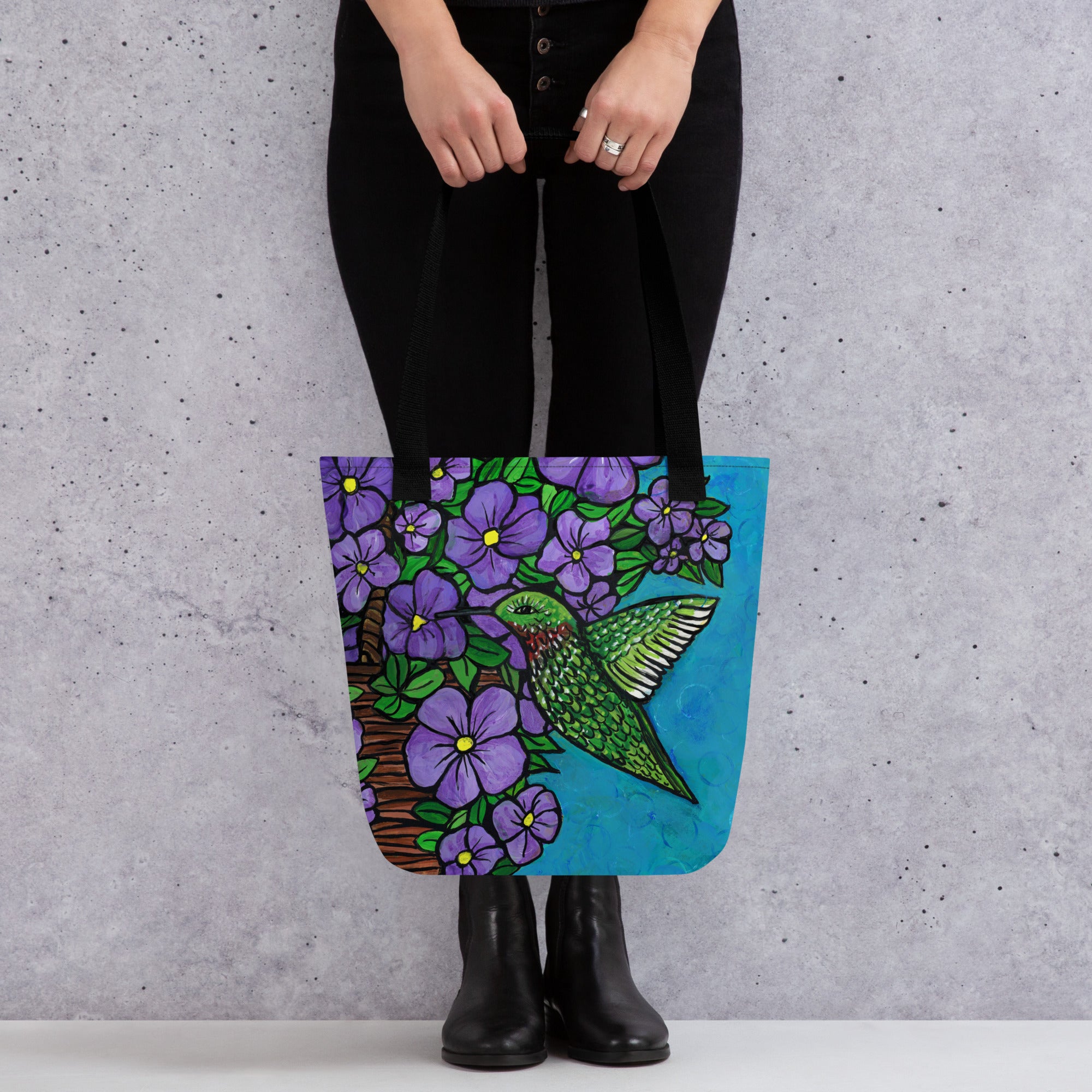 Woman in black clothing holding Hummingbird Tote Bag