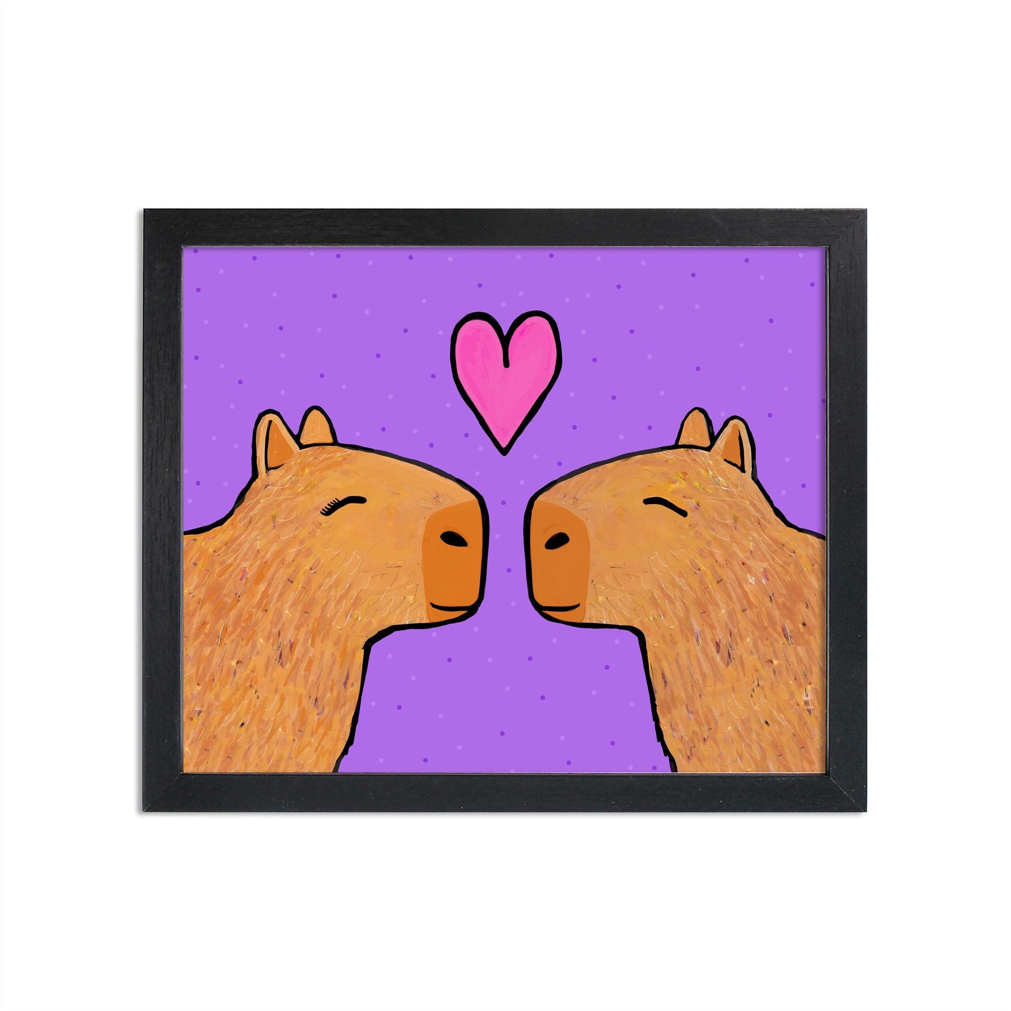 Capybaras in Love art print set in black frame (framed not included). Two brown capybaras with eyes closed facing each other with pink heart above them. Background is purple with small dots.