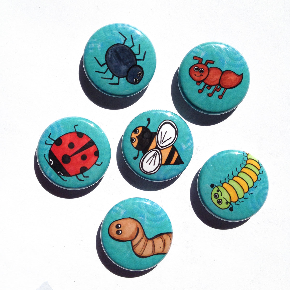 6 round magnets with different bugs - spider, ant, ladybug, bee, caterpillar, and worm on blue swirly background