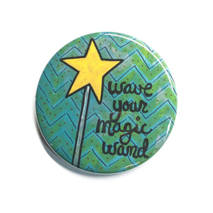 wave your magic wand button with magic wand with yellow star, hand drawn letters, and zig zag background in green and blue
