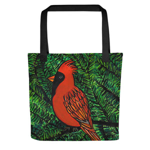 Front view of cardinal tote bag with red cardinal on green pine branches. Bag has black handles