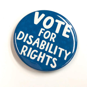 Side view of Vote for Disability Rights pin. Round button with the words Vote for Disability Rights in white and all caps sans serif font. The back ground is blue with slight patterning.