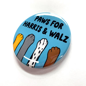 Side view of blue button with words paws for harris & walz and four different animal paws