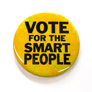 Round yellow button with the words Vote for the Smart People in a black sans serif font. Yellow background has shades of yellow.