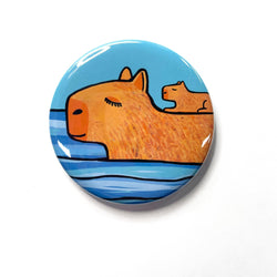 Round button with Capybara Mother with her pup on her back as she swims through the water