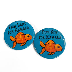 Round blue buttons with a goldfish on them and the words Fish Lady for Kamala on one and Fish Guy for Kamala on the other.