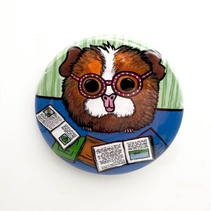 round magnet or pin with Ginger the Guinea Pig reading books