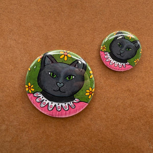 sample sizes of Jane the Black Cat pins and magnets - 1.25 inch and 2.25 inch