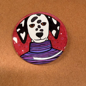 Dottie the Dalmatian is a round pin or magnet available in 2 sizes. She is shown on a brown background.