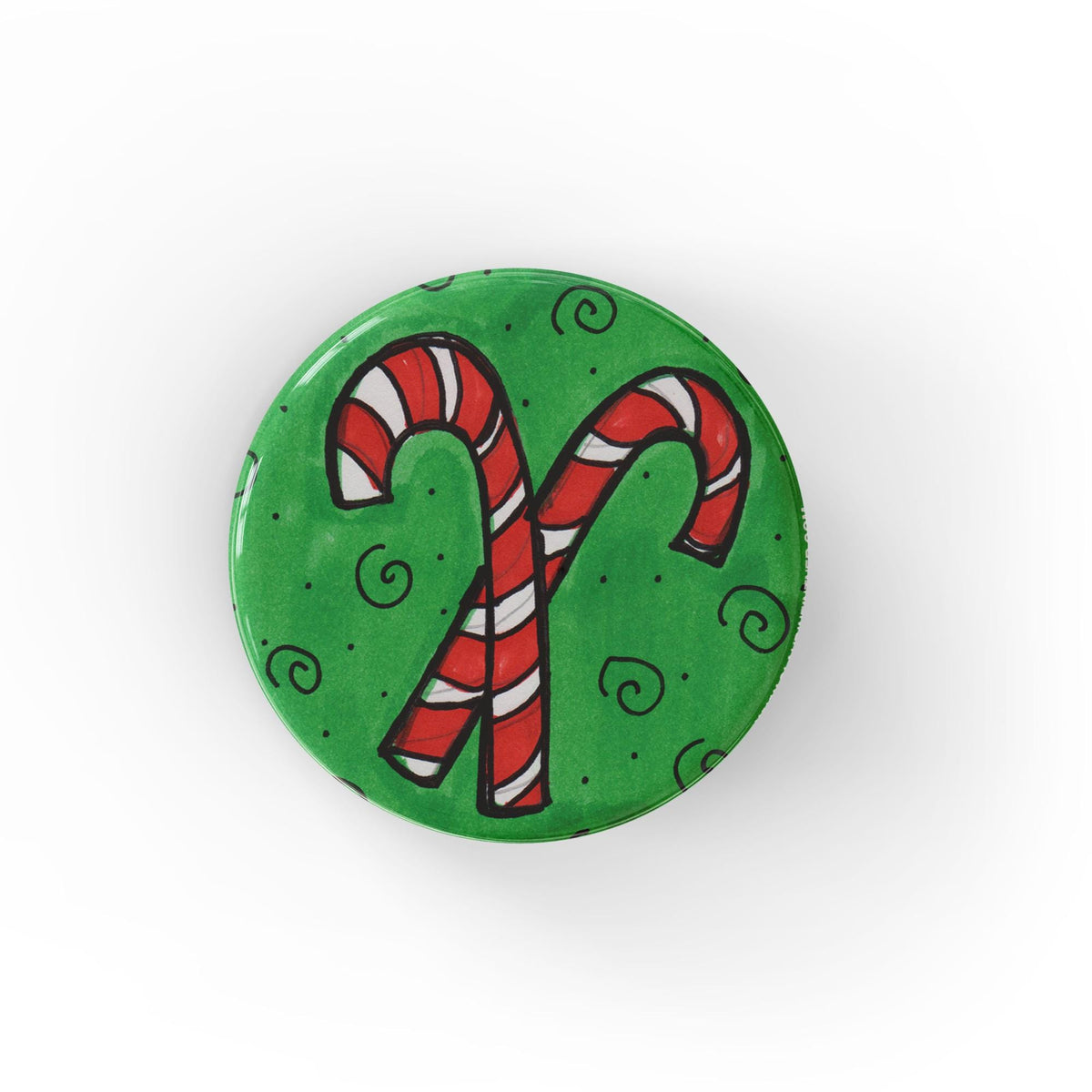 Round green button featuring a pair of hand drawn candy canes criss crossed. The green background has accent swirls and dots.