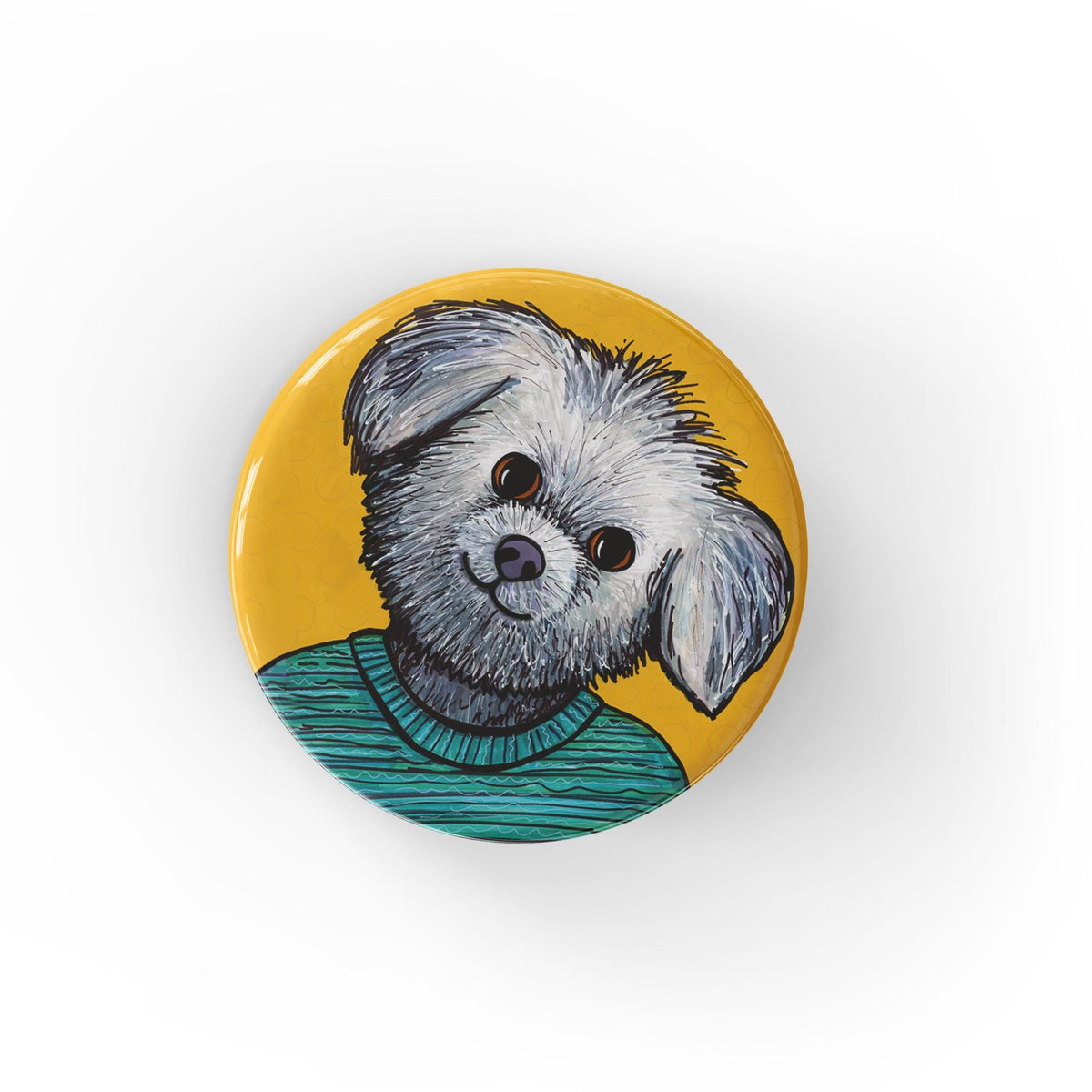 round yellow button with a white and gray shih tzu dog in a turquoise sweater on a yellow ochre background - shown on a white background