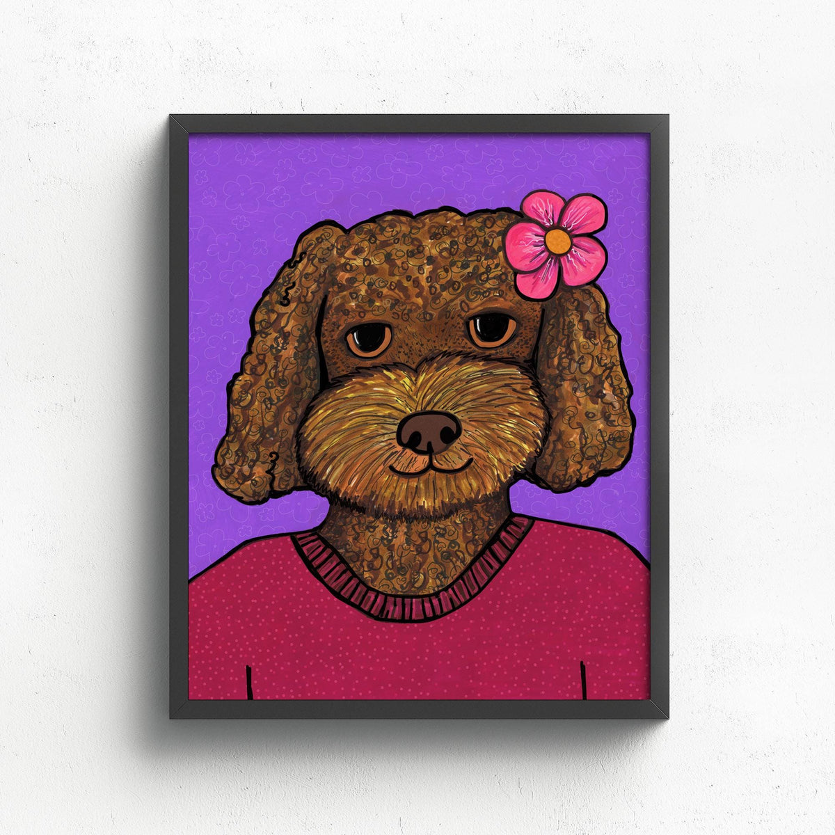 portrait of a brown golden doodle dog wearing a red sweater and pink flower in her fair. the background is purple with subtle swirling lines. shown in a black frame.