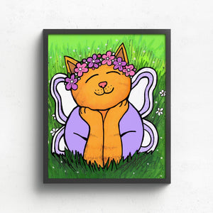 art print of Chloe the Cat Fairy shown in a black frame on a white wall. The yellow tabby cat in wearing purple and pink flower crown and purple shirt. She is laying in the grass with head resting on her hands and her white and purple wings behind her.