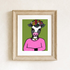 Sophie the Cow art print shown in a wooden frame with white matte on a white wall