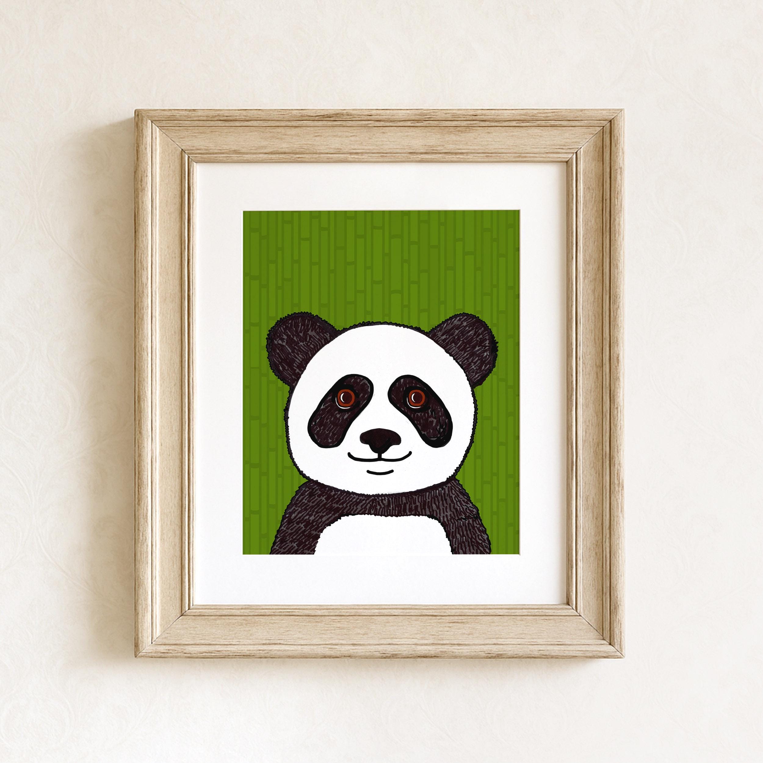Panda art print in a wood frame with white matte on white wall. The print features a black and white panda with brown eyes on a green bamboo background.