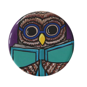 round button with a cute owl in blue glasses holding a book and reading
