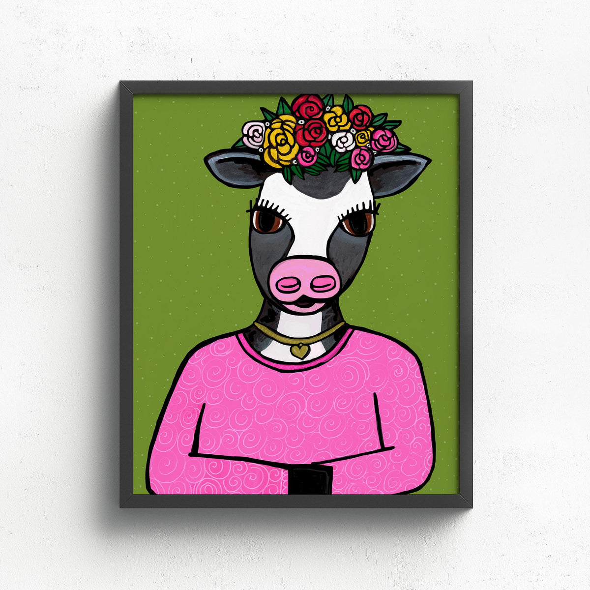 art print featuring a cow in pink shirt, gold heart necklace, and flower crown on a green background
