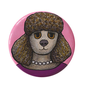 round button with a brown poodle in a deep magenta shirt and white pearl necklace on a pink background