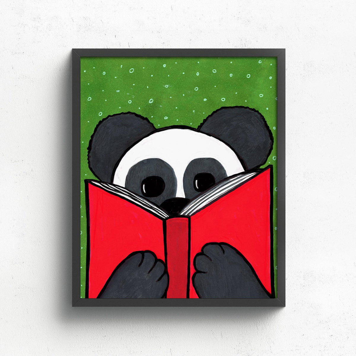 8x10 art print featuring Mandy Panda looking at a red book on a green background with white dots - shown in a black frame on a white wall.