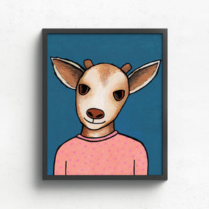 Goldie Goat art print in a black frame on white wall. The art features a brown and white young goat in peach pajamas with little stars and dots on a blue background with subtle dots.