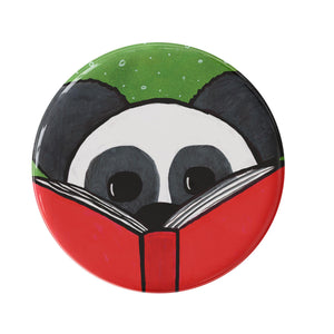 round button with black and white panda reading a red book on a green background with small white dots