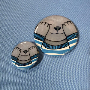 comparison view of 2.25 inch and 1.25 inch gray cat buttons on a blue fabric background