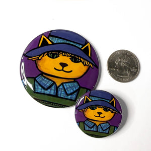 comparison view of 2.25 inch and 1.25 inch scarecrow cat buttons with US quarter