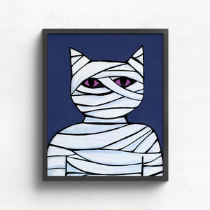 8x10 inch art print featuring Cat Mummy - wrapped in white bandages with piercing purple eyes on dark blue background. Shown in a black frame.