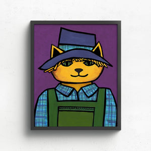 Scarecrow Cat art print shown in a black frame on a white wall. The cat is yellowy orange in a blue hat, green overalls, and blue plaid shirt on a purple background.