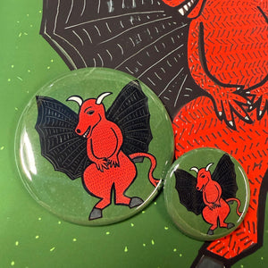 Jersey Devil buttons in two sizes - 2.25 inch and 1.25 inch. Design features a red devil body with black wings and white horns as well as a long red tail.