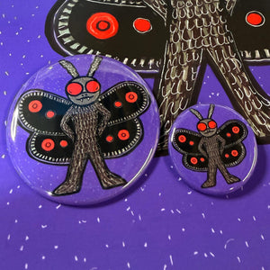 comparison view of two sizes of mothman buttons - 2.25 inch and 1.25 inch.