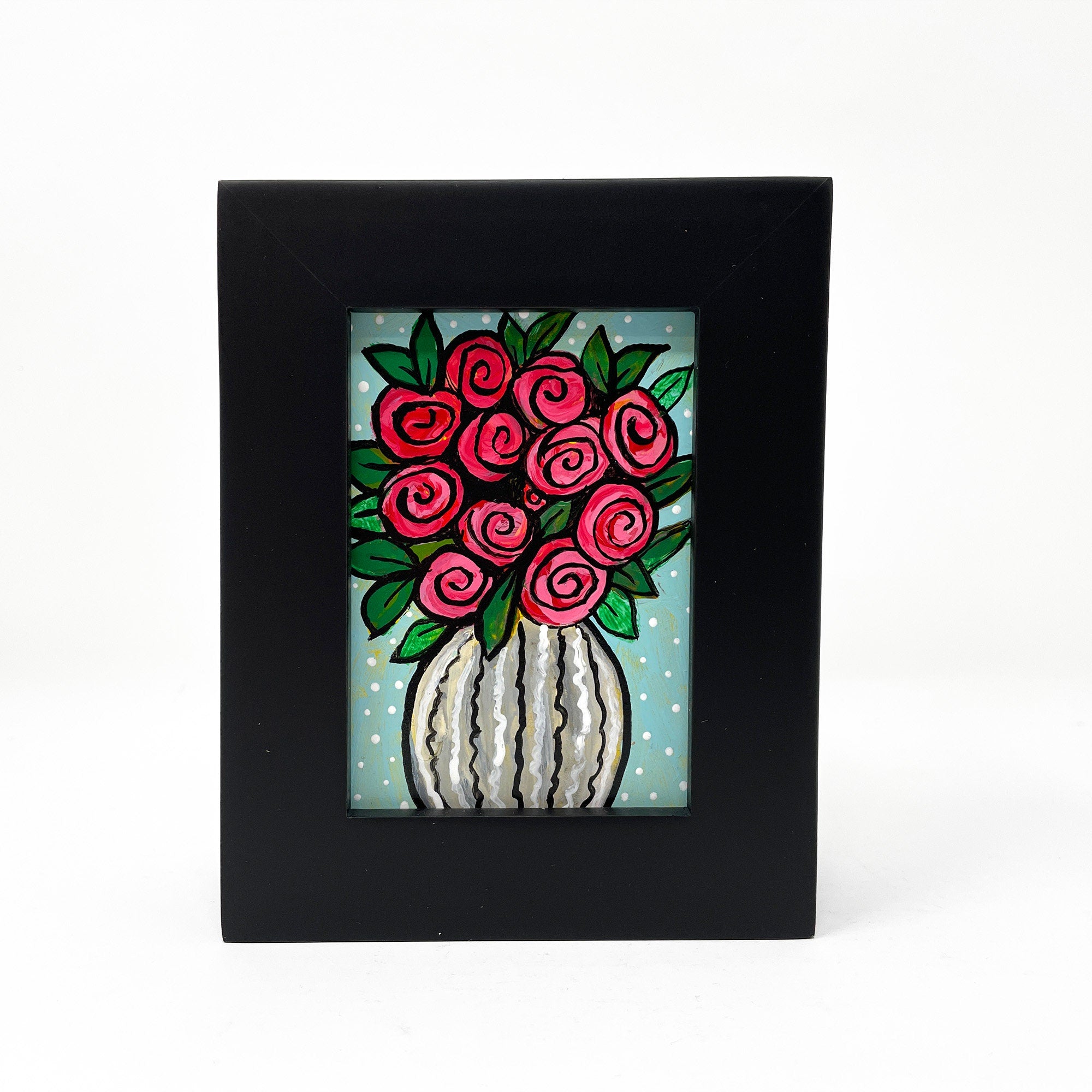 Front view of Vase of Roses painting on white background - White striped vase with red roses and green leaves. Light blue background with white polka dots.
